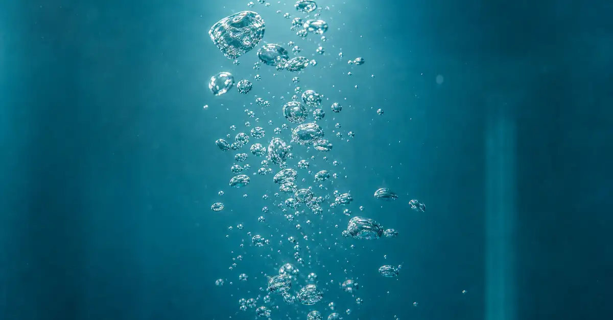 Close-up of gentle rising bubbles in clear aquarium water